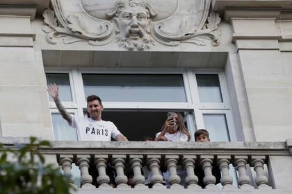 El futbolista argentino Lionel Messi saluda a sus seguidores desde el balcón de su hotel. (AP Foto/Adrienne Surprenant)