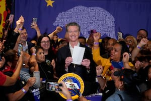 El gobernador de California, Gavin Newsom, muestra que ha firmado un proyecto de ley sobre comida rápida rodeado de trabajadores de ese sector en el Local 721 del sindicato SEIU en Los Ángeles, el jueves 28 de septiembre de 2023. (AP Foto/Damian Dovarganes)