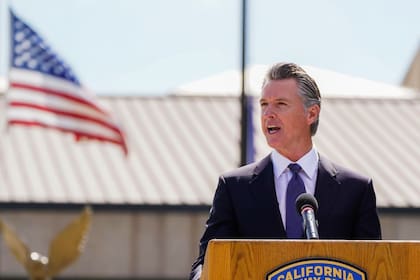 El gobernador de California, Gavin Newsom, muestra que ha firmado un proyecto de ley sobre comida rápida rodeado de trabajadores de ese sector en el Local 721 del sindicato SEIU en Los Ángeles, el jueves 28 de septiembre de 2023.