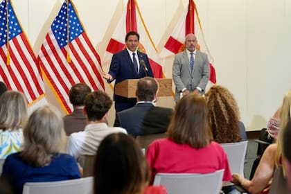 El gobernador de Florida, Ron DeSantis; junto a Blaise Ingoglia, director financiero del estado