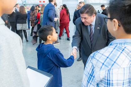 El gobernador de Illinois, JB Pritzker, firmó una ley histórica que garantiza el derecho a la educación pública gratuita para todos los niños sin importar su estatus migratorio, reforzando el fallo Plyler v. Doe de 1982 y estableciendo protecciones específicas contra la discriminación y la colaboración escolar con autoridades migratorias