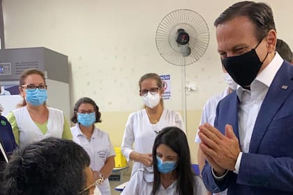 El gobernador de San Pablo, Joao Doria, acompañando a las primeras personas en ser vacunadas en Serrana, como parte del estudio inédito en el mundo para mapear el control de la pandemia con la vacuna.