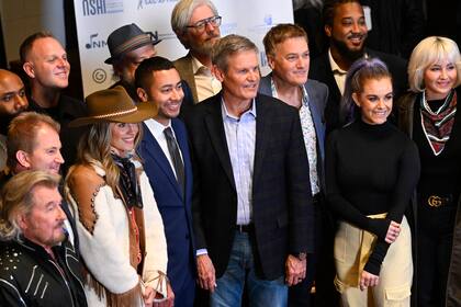 El gobernador de Tennessee, Bill Lee, en el centro, posa con líderes legislativos, artistas, compositores y otros, durante una conferencia de prensa en RCA Records anunciando una nueva legislación diseñada para proteger a los compositores, intérpretes y otros profesionales de la industria musical contra los peligros potenciales de la inteligencia artificial, el miércoles 10 de enero de 2024 en Nashville, Tennessee. (AP Foto/John Amis)