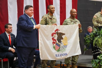 El gobernador JB Pritzker muestra en un acto oficial la bandera actual del estado (Archivo)