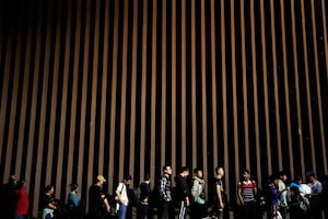 El gobierno de Biden anunció que construirá una sección del muro fronterizo en el sur de Texas. Foto: personas esperan solicitar asilo en Estados Unidos tras cruzar la frontera desde México (archivo)