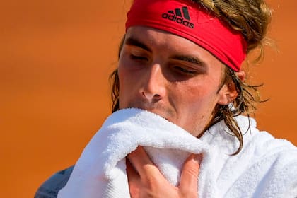 El griego Stefanos Tsitsipas se limpia la cara con una toalla durante su partido contra el italiano Jannik Sinner en el tercer día del Abierto de Italia; se fue rápido del certamen