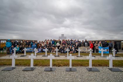El grupo completo de familiares que viajó al cementerio de Darwin con las banderas