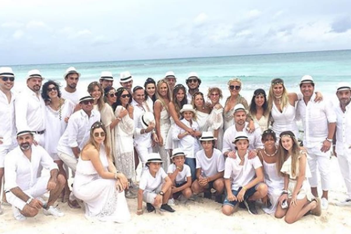 El grupo de invitados íntimos posa para la foto en la arena blanca de Riviera Maya en Mexico