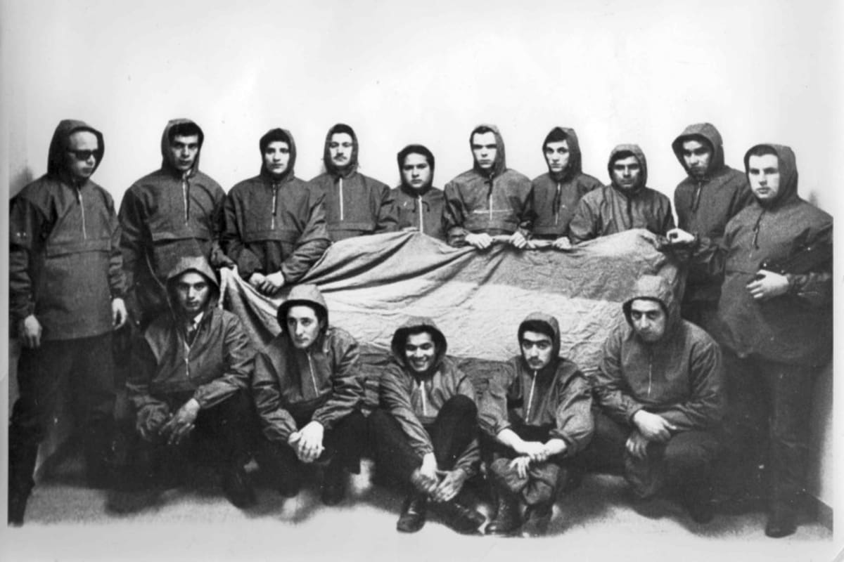 El grupo de militantes que orquestaron el "Operativo Cóndor" junto a una de las banderas desplegadas en Malvinas