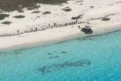 El grupo de personas había escrito SOS sobre la arena para pedir ayuda