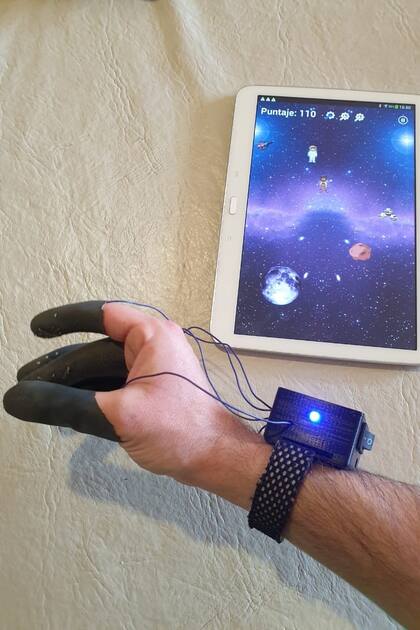 El guante MotFi se vincula a una tableta o smartphone con un videojuego para hacer más entretenida la rehabilitación del movimiento de los dedos de la mano