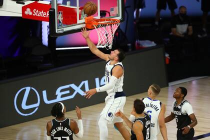 El guardia de los Dallas Mavericks, Luka Doncic (77) encesta contra los Sacramento Kings en la segunda mitad de un partido de baloncesto de la NBA el martes 4 de agosto de 2020, en Lake Buena Vista, Florida