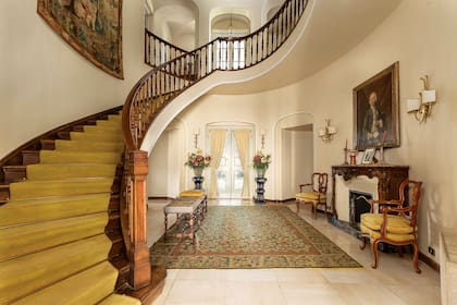 El hall de entrada y la escalera de madera que conecta las distintas plantas.