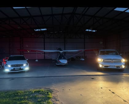 El hangar de Alvear, Santa Fe, con el hidroavión flanqueado de dos autos