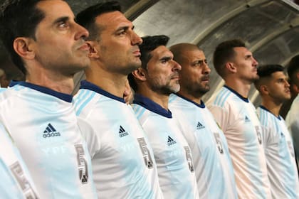 El homenaje a Brown desde el banco, con Martín Tocalli (entrenador de arqueros), el DT Lionel Scaloni y los asistentes Roberto Ayala y Walter Samuel, Franco Armani y Exequiel Palacios
