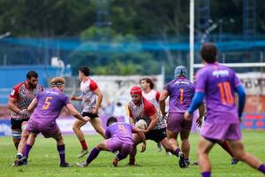 El hooker de Pampas, Ramiro Gurovich, recibe un tackle de Douglas Rauth, el medio-scrum de Cobras Brasil XV, en el debut de ambos equipos en el Super Rugby Américas, en San Pablo; el segunda línea Federico Lavanini está listo para la descarga del primera línea.