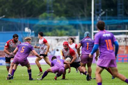 El hooker de Pampas, Ramiro Gurovich, recibe un tackle de Douglas Rauth, el medio-scrum de Cobras Brasil XV, en el debut de ambos equipos en el Super Rugby Américas, en San Pablo; el segunda línea Federico Lavanini está listo para la descarga del primera línea.