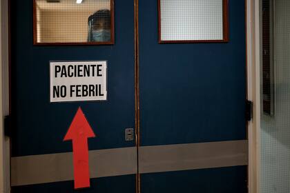 Un cartel que señala por donde llevar a los pacientes sin fiebre. Todos los carteles que servían para señalizar los consultorios, ahora quedaron viejos.