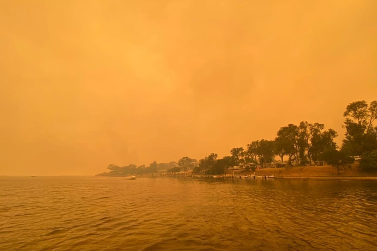 El humo de los incendios forestales salvajes envuelve el cielo en Mallacoota, Victoria, Australia, el 31 de diciembre de 2019. Las informaciones de varias zonas turísticas dan cuenta de miles de turistas y lugareños que pasaron la Nochevieja a orillas del mar, acorralados por las llamas, sobre todo