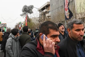 El humo de una explosión se levanta detrás de los manifestantes que asistieron a la manifestación del Día Quds, en Teherán