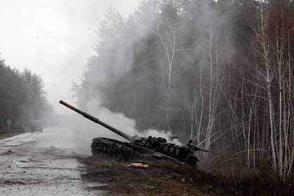 El humo se eleva desde un tanque ruso destruido por las fuerzas ucranianas en el lado de una carretera en la región de Lugansk el 26 de febrero de 2022.