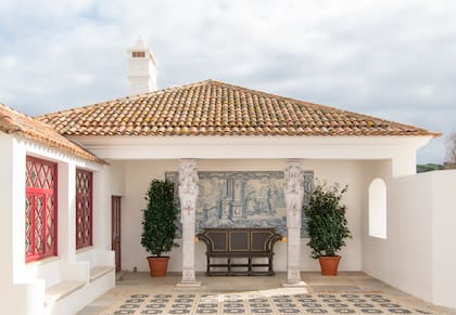 El ineludible rojo en las aberturas convive con las columnas del escultor italiano Giuseppe Ducrot, antiqüedades recuperadas y azulejos típicos de la región de Alentejo, encargados a la fábrica Azulejos de Azeitão.