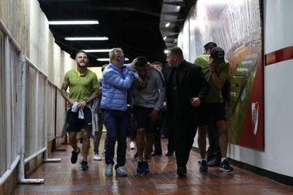 El ingreso de Horacio Paolini (campera celeste) al vestuario del Monumental, protegiendo a Tevez y junto a Nández