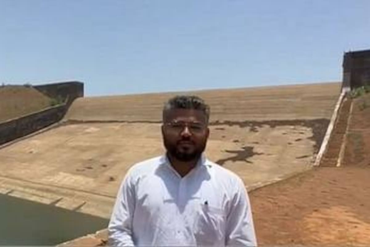 El inspector de alimentos Rajas Vishwas posa con el fondo de la presa que ordenó vaciar
