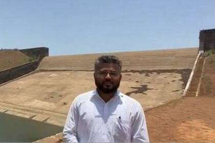 El inspector de alimentos Rajas Vishwas posa con el fondo de la presa que ordenó vaciar