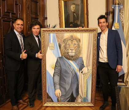 El intendente de Gualeguaychú, Mauricio Davico, el presidente Javier Milei y el artista Yari Casanova rodean el cuadro Presidente de la Argentina, que le regalaron al mandatario