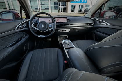 El interior cuenta con materiales de aceptable calidad y una pantalla central de 10,25″