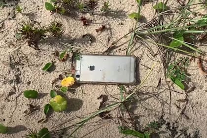 El iPhone 6S, recuperado al día siguiente tras la caída desde 300 metros, en la arena, cerca del mar y con una carga mínima de la batería