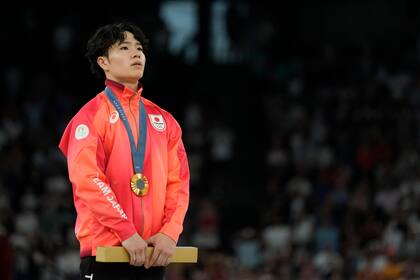 El japonés Shinnosuke Oka parado en el podio tras recibir su medalla de oro tras ganar el All-Around de la gimnasia masculina en la Arena Bercy en los Juegos Olímpicos de París el miércoles 31 de julio del 2024. (AP Foto/Abbie Parr)