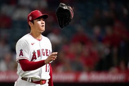 El japonés Shohei Ohtani, de los Angelinos de Los Ángeles, juguetea con el guante al concluir la parte alta del cuarto inning del juego ante los Rangers de Texas, el viernes 3 de septiembre de 2021 (AP Foto/Ashley Landis)