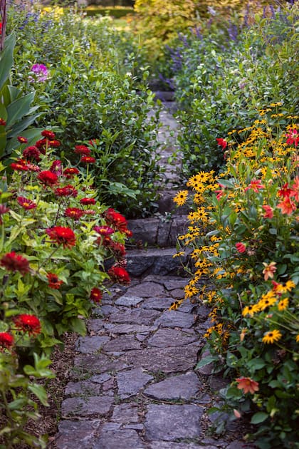 El jardín con sus canteros repletos de flores tiene el sello de su dueña.