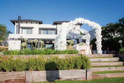 El jardín de la casa ambientado con globos blancos y un
techo de luces.