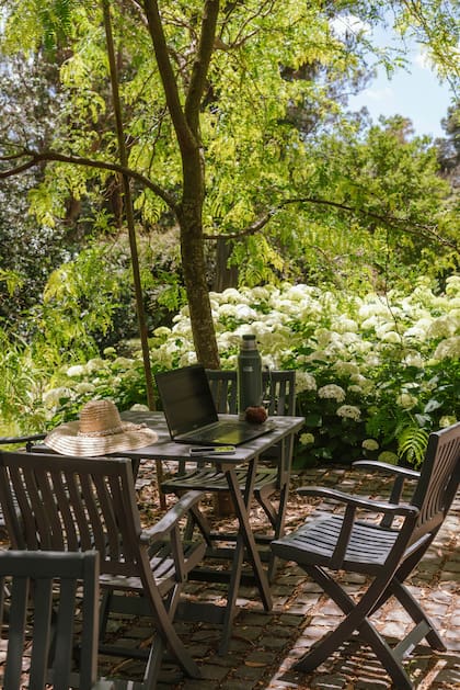 El jardín tiene un equipamiento de lo más sencillo: mesas y sillas de madera plegables