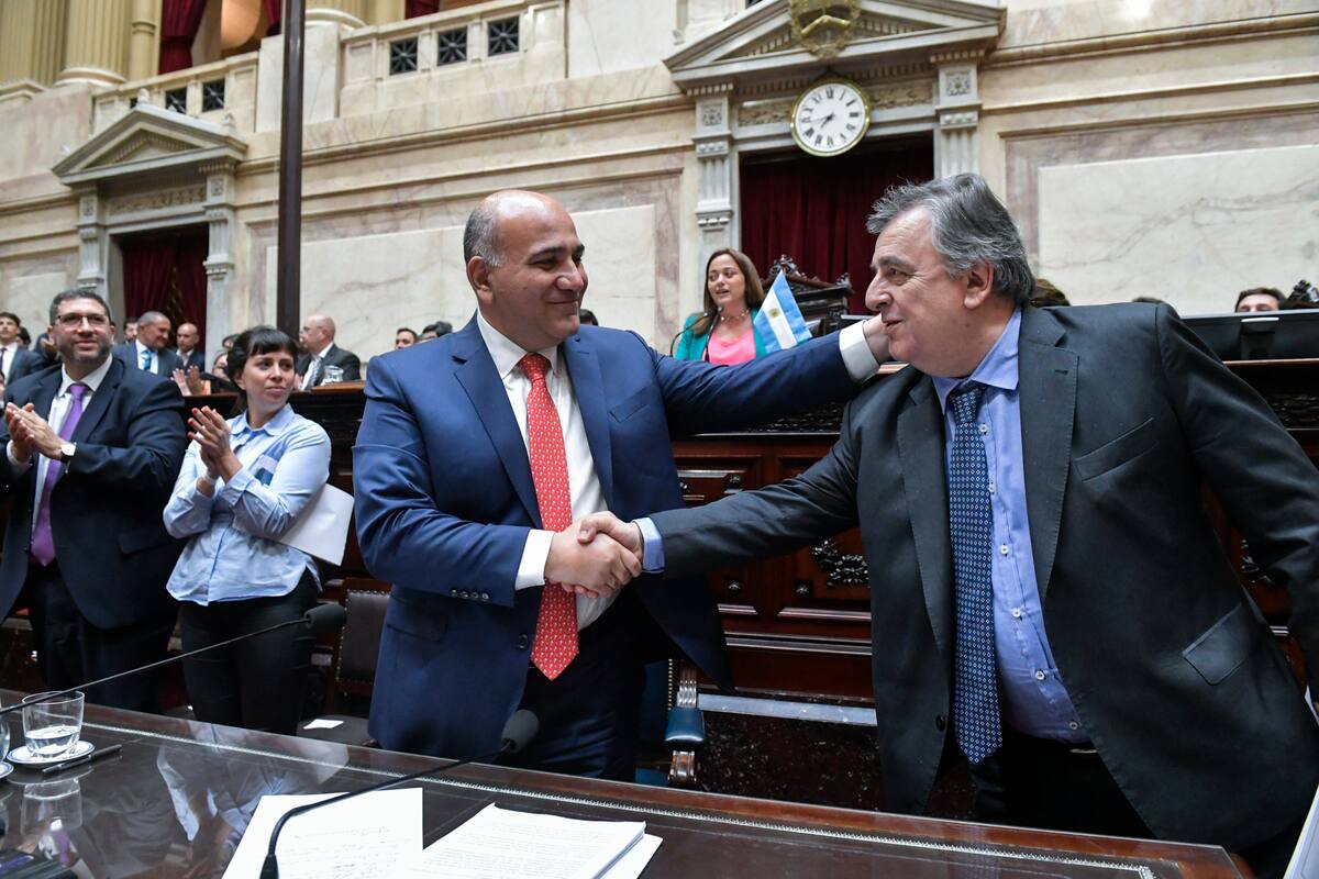 El jefe de Gabinete, Juan Manzur, y el titular del bloque de diputados de la UCR, Mario Negri, se estrechan la mano