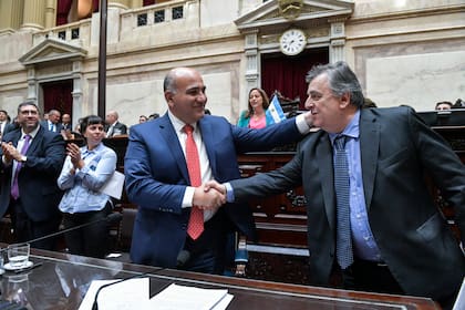 El jefe de Gabinete, Juan Manzur, y el titular del bloque de diputados de la UCR, Mario Negri, se estrechan la mano