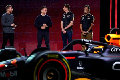 El jefe de la escudería Christian Horner, el campeón Max Verstappen y el mexicano Sergio Checo Pérez, con el modelo RB18, el auto con el que Red Bull Racing pretende replicar el título que logró el piloto neerlandés el año pasado