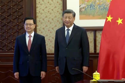 El jefe del ejecutivo de Hong Kong, John Lee, izquierda, está junto al presidente chino Xi Jinping en Beijing, viernes 23 de diciembre de 2022. El presidente chino Xi Jinping reafirmó el compromiso de Beijing de respetar el principio de gobernanza de "un país, dos sistemas" para Hong Kong. (Pool via AP Photo)