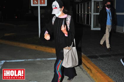 El jueves 26, Juana llegó a Buenos Aires, enmascarada, con un cap, pantalón ancho y sandalias con medias