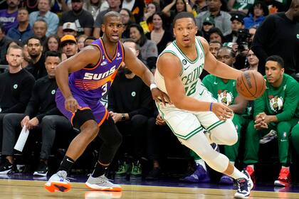 El jugador de los Celtics de Boston Grant Williams pasa junto al jugador de los Suns de Phoenix Chris Paul (3) en la primera mitad de su juego de NBA, el miérocles 7 de diciembre de 2022, en Phoenix. (AP Foto/Rick Scuteri)