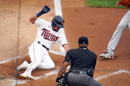 El jugador de los Mellizos de Minnesota Luis Arráez anota desde tercera base en un wild pitch del lanzador de los Indios de Cleveland J.C. Mejía en el primer inning del juego de la MLB que enfrentó a ambos equipos, el 24 de junio de 2021, en Minneapolis (AP Foto/Jim Mone)