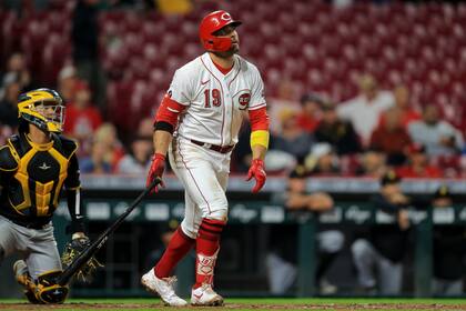 El jugador de los Rojos de Cincinnati Joey Votto (con el 19) mira su jonrón solitario en el quinto inning de su juego de béisbol contra los Piratas de Pittsburgh, en Cincinnati, el lunes 20 de septiembre de 2021. (AP Foto/Aaron Doster)