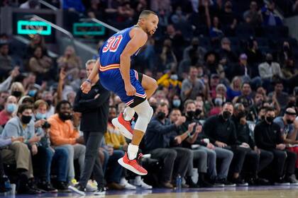 El jugador de los Warriors de Golden State Stephen Curry reacciona tras lanzar un triple en la segunda mitad del juego de la NBA que enfrentó a su equipo con los Bulls de Chicago, en San Francisco, el 12 de noviembre de 2021. (AP Foto/Jeff Chiu)