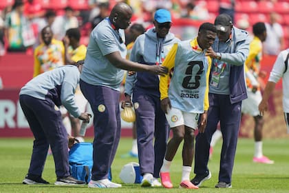 El jugador de Senegal, Lamine Camara (8), es ayudado a salir del campo de juego antes del partido de fútbol del Grupo I de la Copa Mundial entre Senegal e Irak en Toronto, el viernes 26 de junio de 2026.