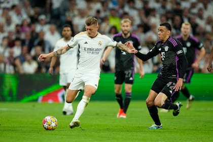 El jugador del Real Madrid Toni Kroos (izquierda) protege el balón ante Jamal Musiala, del Bayern Múnich, durante el partido de vuelta de las semifinales de la Liga de Campeones, en el estadio Santiago Bernabeu, en Madrid, el 8 de mayo de 2024. (AP Foto/José Bretón)