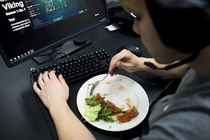 El jugador Patrik Jiru del equipo Origen almuerza salmón y vegetales en su escritorio mientras entrena una partida de League of Legends