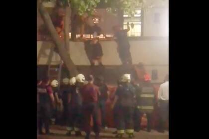 El ladrón en el momento en el que es salvado por los bomberos y la policía